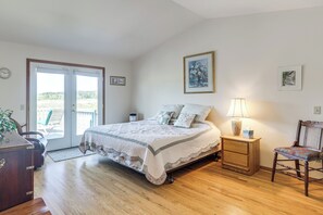 A bedroom with a bed, a nightstand, a chair, a lamp, and a view through a door. - < 1 Mi to Beach! Ocean-View Getaway in Freeland (Freeland)