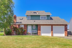 A two-story house with a green front, a white garage door, and a brick chimney. - < 1 Mi to Beach! Ocean-View Getaway in Freeland (Freeland)