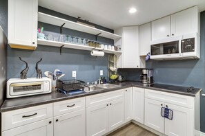 A kitchen with white cabinets, a microwave, a toaster, and various kitchen utensils. - 5 Mi to Barr Lake! Suburban Family Retreat (Brighton)
