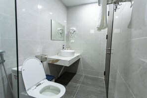A modern bathroom with a toilet, sink, and glass shower enclosure. - The Sun Hotel - Ninh Bình (Ninh Binh)