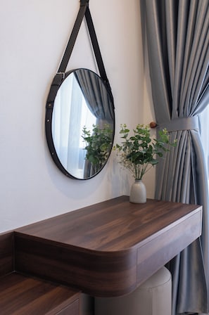 A bathroom vanity with a mirror, a vase with flowers, and a towel. - The Sun Hotel - Ninh Bình (Ninh Binh)