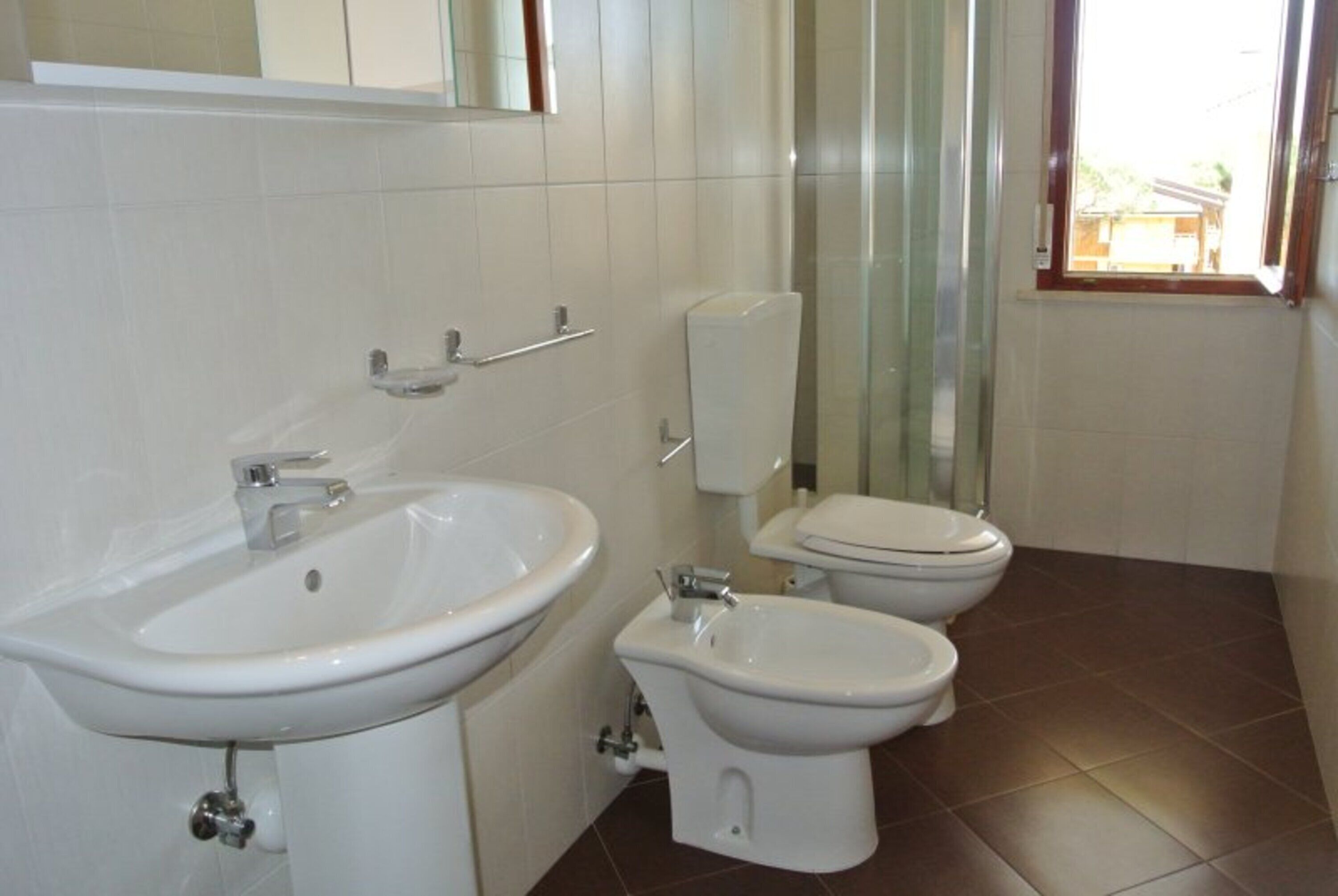 Un baño con lavamanos, un bidé y un inodoro.
