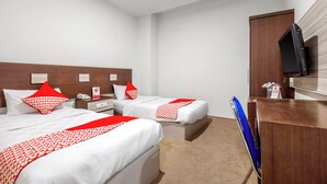 Een hotelkamer met twee bedden, een bureau, een televisie en een minibar.
