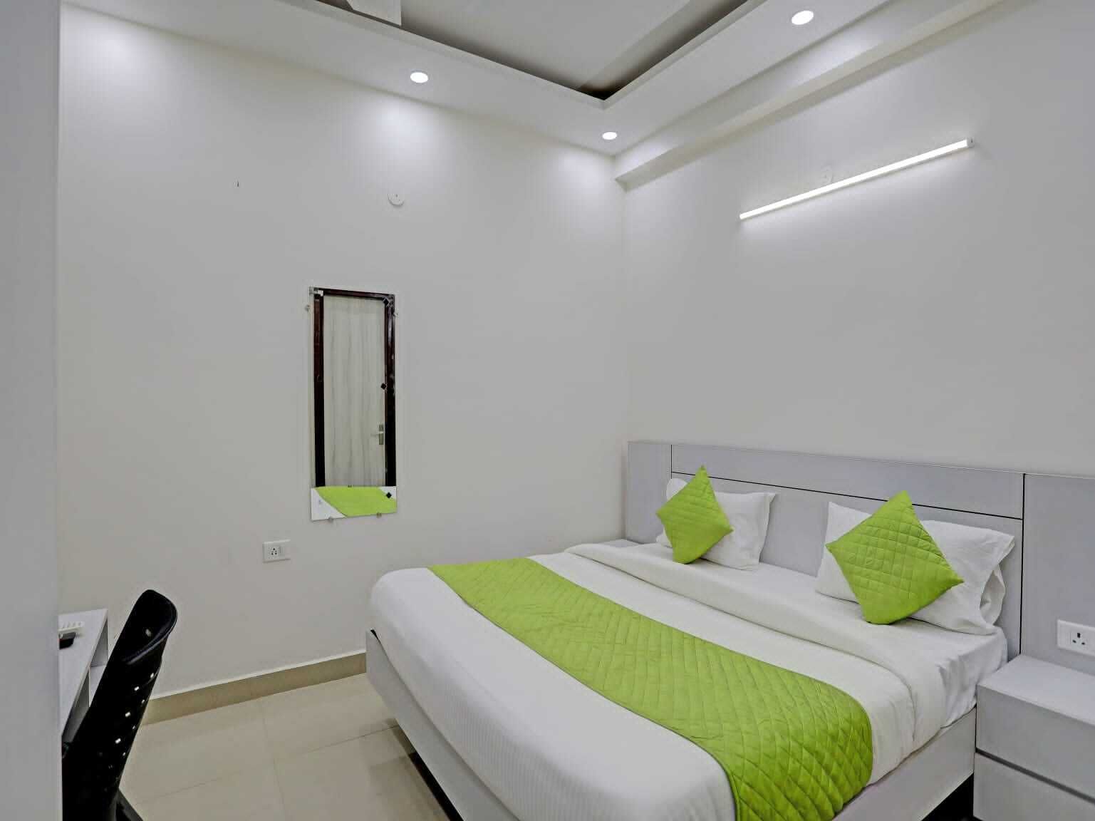 Un dormitorio moderno con cama, mesitas de noche, una ventana y una silla.