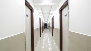 A long, well-lit hallway with doors numbered 205 and 209, leading to rooms. - The Vertigo (Noida)