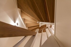 Una escalera moderna con escalones de madera y barandillas blancas.