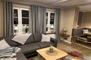 A modern living room with a sofa, a coffee table, and a seating area with a bench. - Holiday home with 3 bedrooms (Stelle- Wittenwurth)