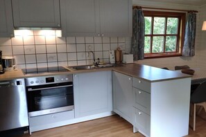 A compact kitchen with a built-in oven, a sink, and a window with curtains. - Farm in Boren with swimming pool (Boren)