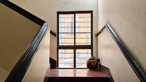 A staircase with a potted plant on the landing. - Amit Hotel (Kolkata)