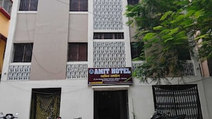A hotel building with a sign reading 'AMIT HOTEL' and another sign with contact details. - Amit Hotel (Kolkata)