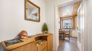 A wooden desk with magazines, a mirror, and a small Christmas tree.