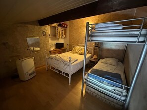 A compact room with bunk beds, a small bedside table, a TV, and a wall-mounted shelf. - T2 Apartment 5 Minutes from the Beach with Wi-Fi and Air Conditioning (Six-Fours-les-Plages)