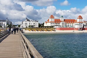 Eine hölzerne Steg, der sich über ein Gewässer erstreckt, mit Gebäuden im Hintergrund.