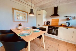 Eine moderne Küche mit weißen Schränken, einer schwarzen Dunstabzugshaube und einer Holz Arbeitsplatte.