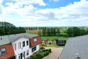 Ein Wohnhaus mit Auffahrt, Schaukel und umzäunter Grundstück.