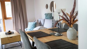 A dining area with a wooden table, black placemats, and grey chairs.