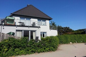 A two-story house with a balcony, a garage, and a driveway. - with garden and terrace (Glowe)