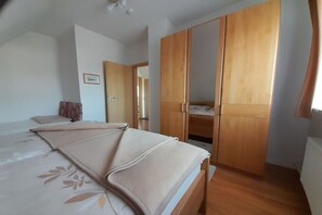 Ein Schlafzimmer mit einem Bett, einem Kleiderschrank und einer Tür zu einem anderen Raum.