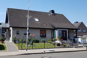 Ein Wohnhaus mit Ziegeldach, Hauseingang, einer kleinen Fenster und einem Briefkasten.