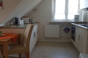 Eine kleine Küche mit Essbereich, einem Fenster und einer Heizung.