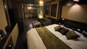A hotel room with a bed, a desk, a chair, a sofa, a TV, and a bathroom. - HOTEL CACHE - Adults only  (Himeji)
