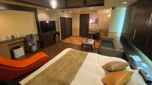 A hotel room with a bed, a TV, a desk, and a seating area. - HOTEL CACHE - Adults only  (Himeji)