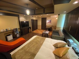 Camera d'albergo con un letto, una TV, una scrivania e un'area salotto.