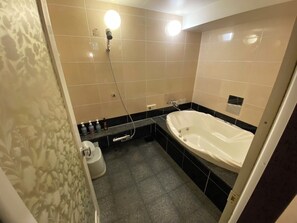 Un bagno con vasca, doccia e servizi igienici.