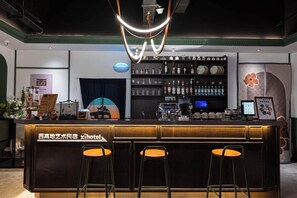 Una zona de bar con taburetes, una barra y una máquina de café.