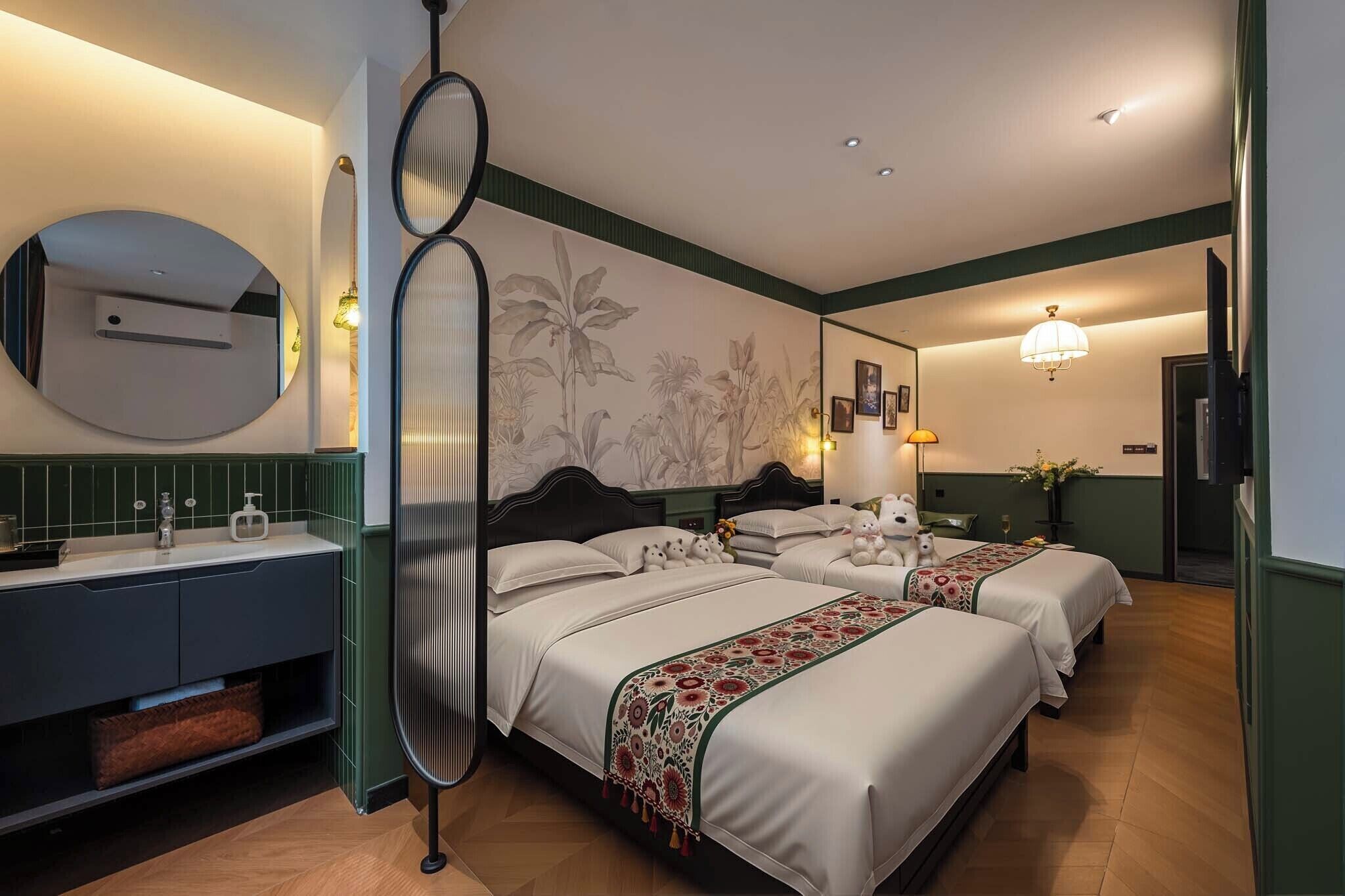 Une chambre d’hôtel comprenant un lit, des tables de chevet, un miroir, un climatiseur fixé au mur et un panneau décoratif mural.