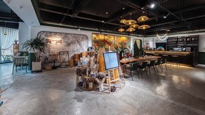 A modern interior with a bar area, seating, and a mural. - Xigaodi Art Homestay Hotel  (Guiyang)