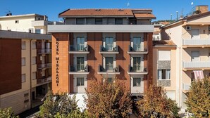 A multi-story hotel with balconies, a tiled roof, and a brick facade. - Hotel Miralaghi Family & Sport (Chianciano Terme)
