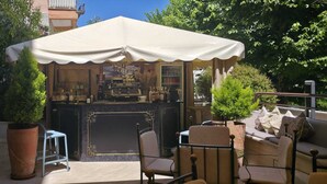 A café with a white canopy, outdoor seating, and a bar area. - Hotel Miralaghi Family & Sport (Chianciano Terme)