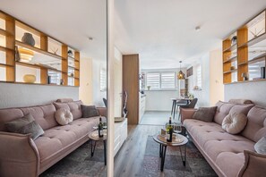 A modern living room with two sofas, a coffee table, and a dining area with a table and chairs.