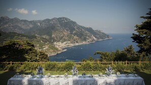 A table set for a meal with a view of a coastal landscape and mountains. - Villa in Ravello with 6 bedrooms sleeps 15 (Ravello)