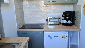 Eine kleine Küche mit einem Toaster, einer Kaffeemaschine und einem Kühlschrank.
