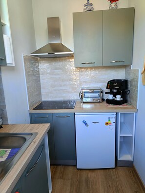 Eine kleine Küche mit einem Toaster, einer Kaffeemaschine und einem Kühlschrank.