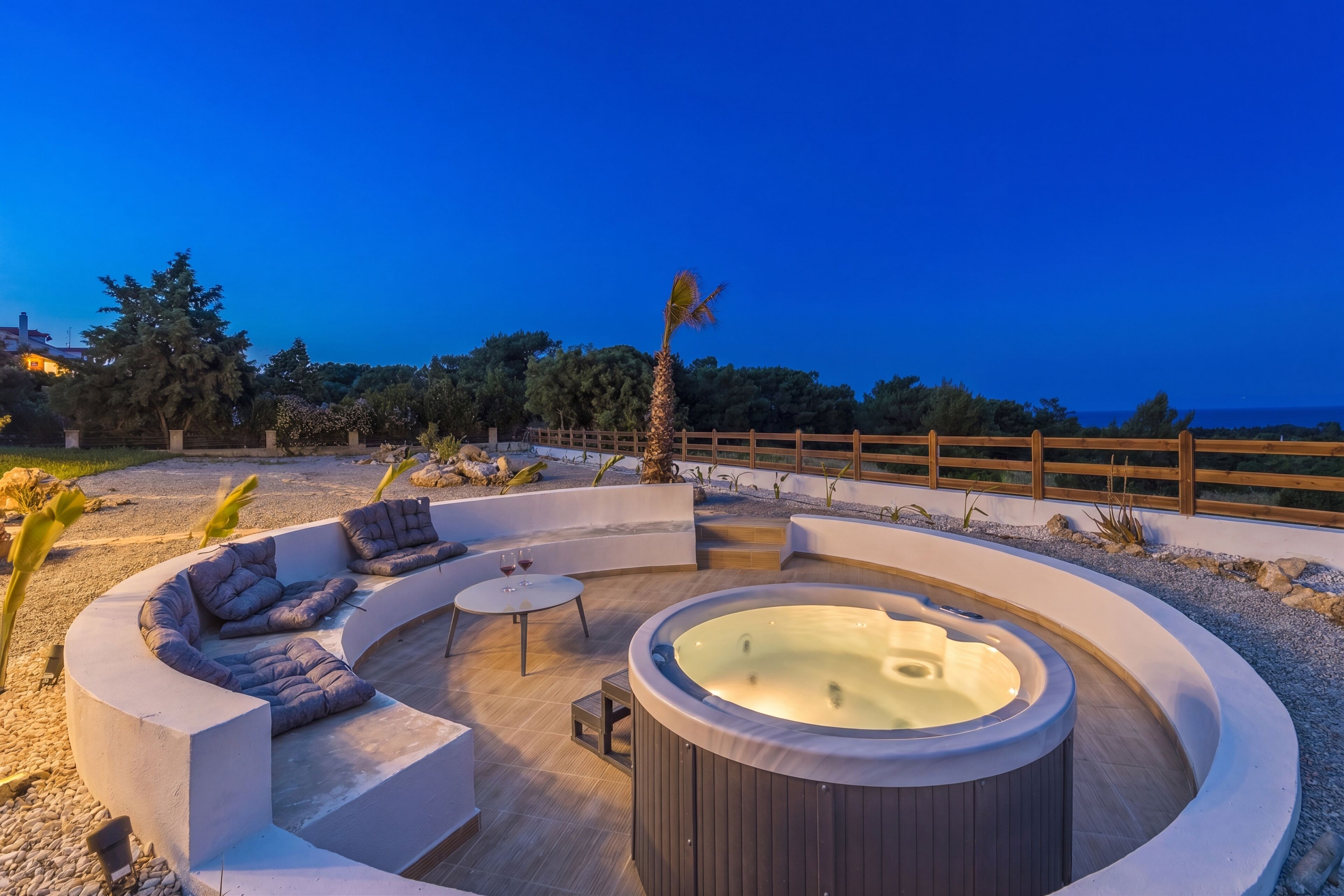 A circular outdoor hot tub area with seating and a small table.