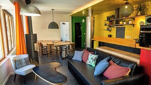 Un soggiorno moderno con divano, poltrone, tavolo da pranzo e angolo cottura.
