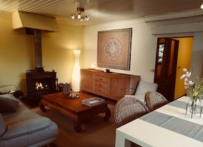 A cozy living room with a fireplace, a wooden cabinet, a sofa, and a coffee table.