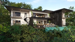 Ein modernes, zweistöckiges Haus mit Dachterrasse, Swimmingpool und üppiger Bepflanzung rund um das Anwesen.
