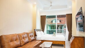 A bedroom with a bed, a sofa, a small table, a ceiling fan, and a TV on the wall. - #1 Luxury 4BR Resort Poolvilla Pratamnak Residence (Pattaya)