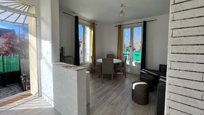 Un interior moderno con comedor, chimenea y ventanas amplias.