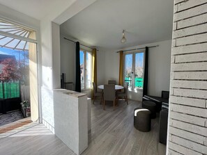 Ein modernes Interieur mit Essbereich, Kamin und großen Fenstern.