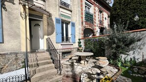 Un patio con escalones de piedra, una mesa redonda y asientos al aire libre.