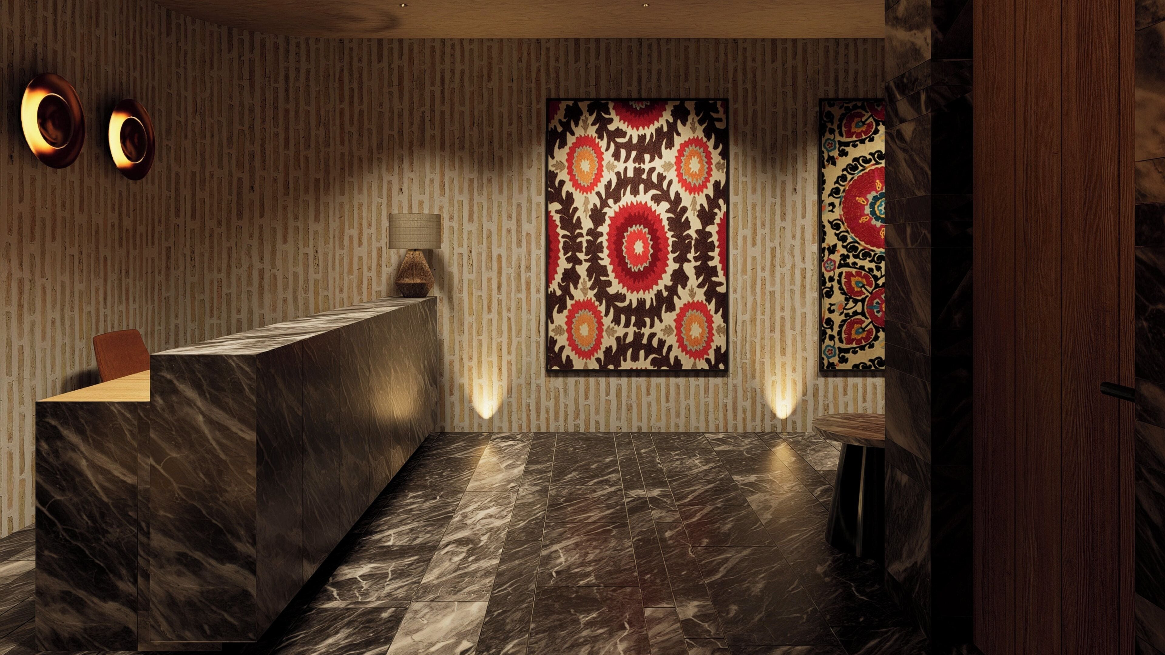Una zona de recepción con mostrador de mármol, decoración mural con diseños y una puerta de madera.