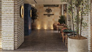 A restaurant interior with brick walls, a blue accent wall, a sign reading 'RESTAURANT TUT,' and a dining area with chairs and tables. - Hotel Indigo Bukhara by IHG (Bukhara)