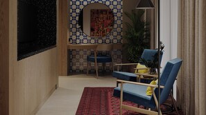 A room with a wooden floor, a red patterned rug, a blue chair, a round mirror, and a wall with a geometric tile pattern. - Hotel Indigo Bukhara by IHG (Bukhara)