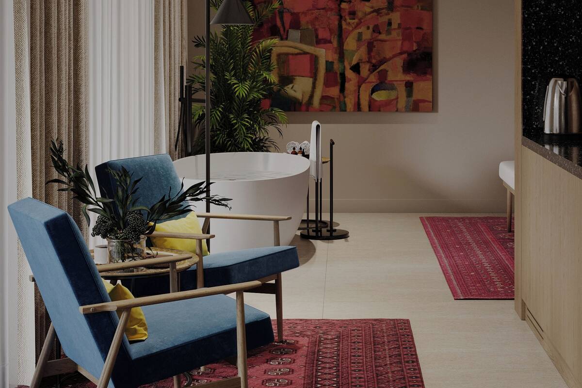 A modern living room with a blue armchair, a white bathtub, and a large abstract painting on the wall.