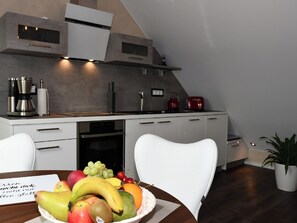 A modern kitchen with a built-in oven, a coffee machine, and a red kettle. - Zimmermann's Lounge 7 - stylish vacation apartment in a central location (Monschau)